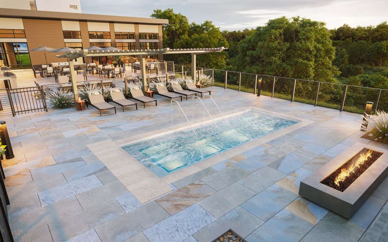 a rooftop courtyard with a pool, chairs and fire pit