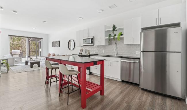 a kitchen with a red table and white cabinets